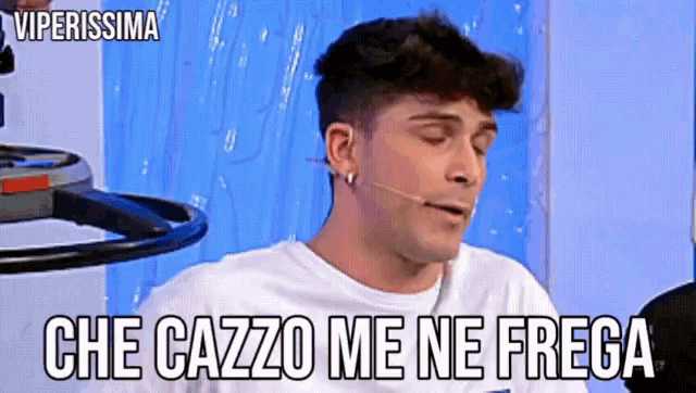 a man with a microphone in his mouth and the words che cazzo me ne frega above him