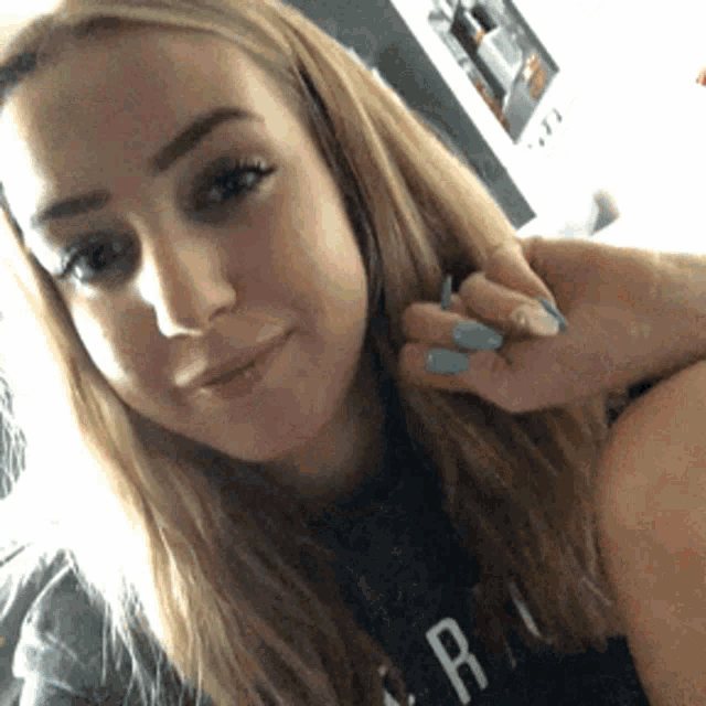 a woman taking a selfie with a shirt that says r on it