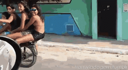 a girl in a bikini is riding on the back of a motorcycle with two other girls