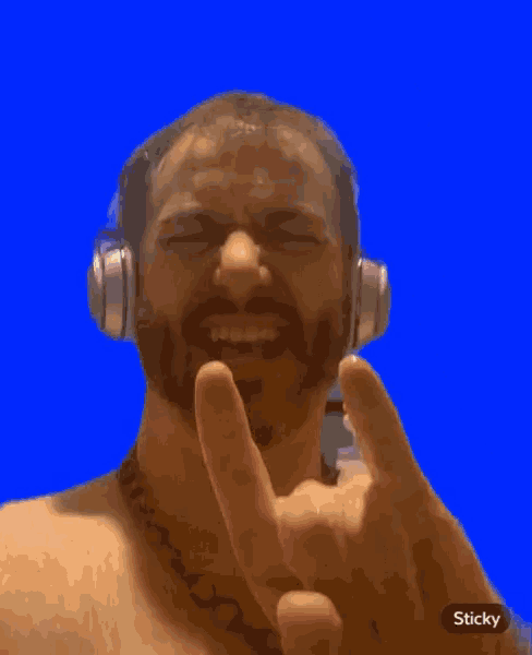 a man wearing headphones is making a peace sign with his fingers