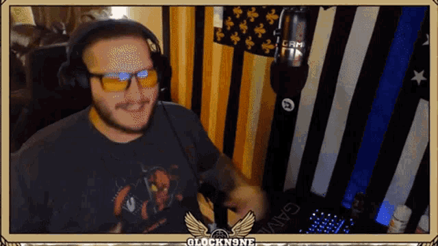 a man wearing glasses and headphones is sitting in front of a microphone with the words glockn9ne above him