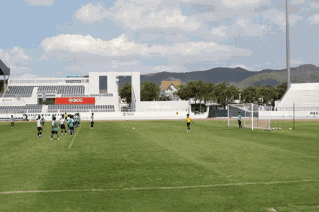 a group of soccer players on a field with a scg stadium in the background