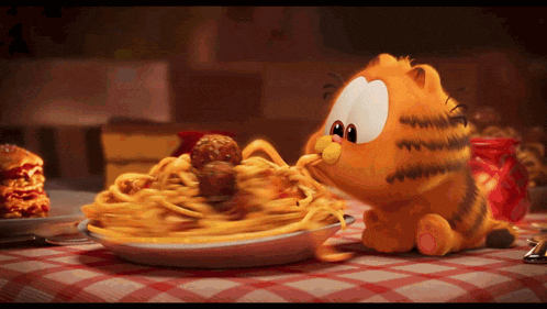 garfield eating spaghetti and meatballs on a table