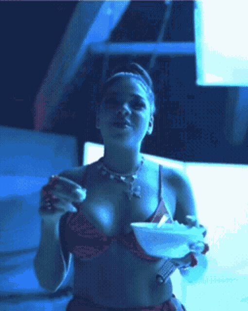 a woman in a bikini is holding a bowl of food
