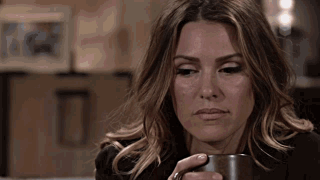a woman sitting on a couch holding a coffee mug