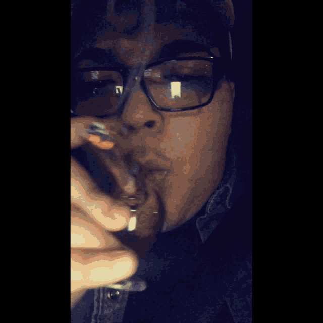 a person wearing glasses is smoking a cigarette