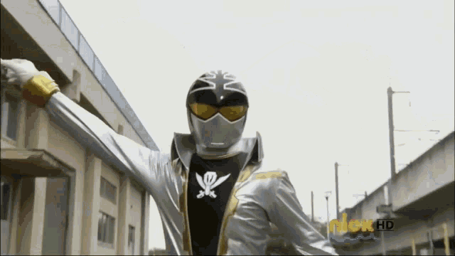 a man in a silver and black costume is standing in front of a building that says nick hd on the bottom