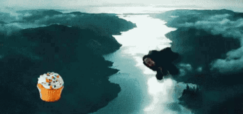 a cupcake with frosting is flying over a body of water .