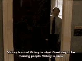 a man in a suit and tie is running through a doorway and says victory is mine !