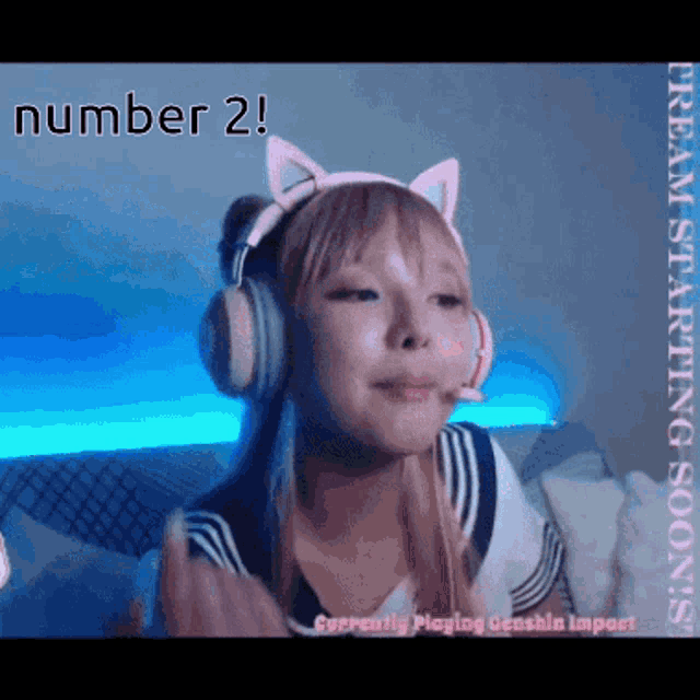 a girl wearing headphones and a cat ear headband says number 2 on the screen