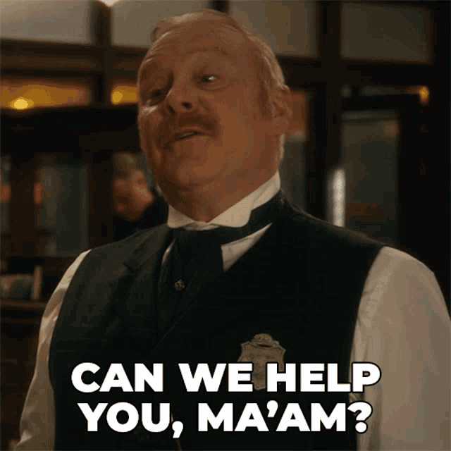 a man in a vest and tie says " can we help you ma am "