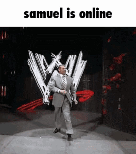 a man in a suit and tie is walking on a stage with the words samuel is online written above him .