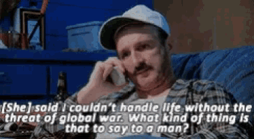 a man sitting on a couch talking on a cell phone with a caption that says she said i couldn 't