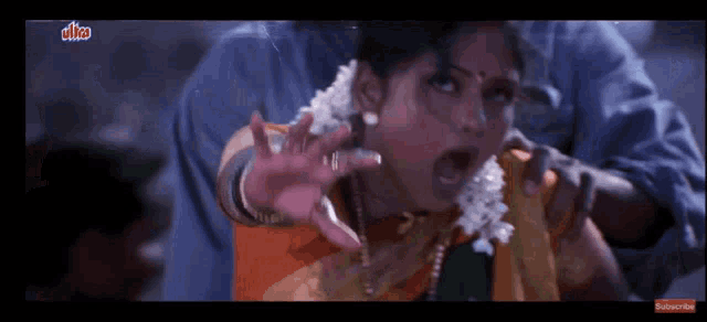 a woman in a yellow saree is being held by a man in a blue shirt with ulka written on it