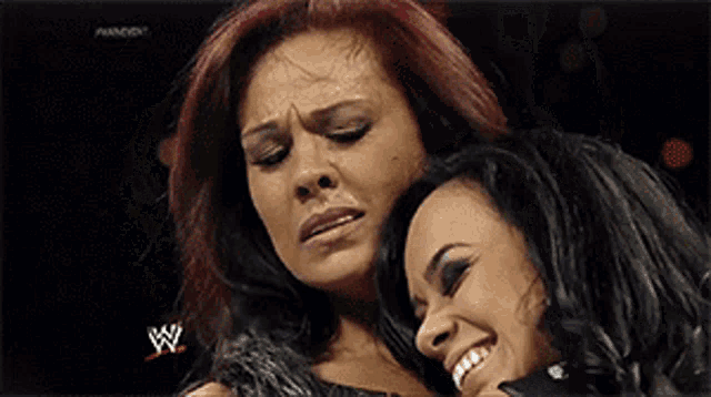 two women are hugging each other with a w logo on the bottom