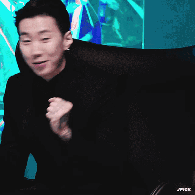 a man with a tattoo on his arm is sitting in a chair with his arms outstretched and the word jpick below him
