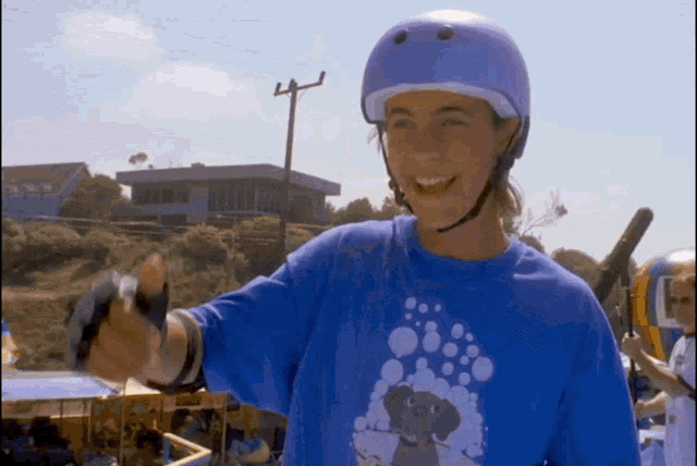a woman wearing a helmet and a blue shirt with an elephant on it