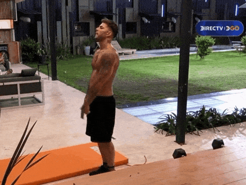 a shirtless man is standing in front of a sign that says directv