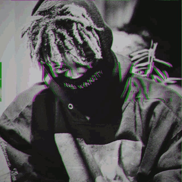 a black and white photo of a person with dreadlocks wearing a mask that says vanity