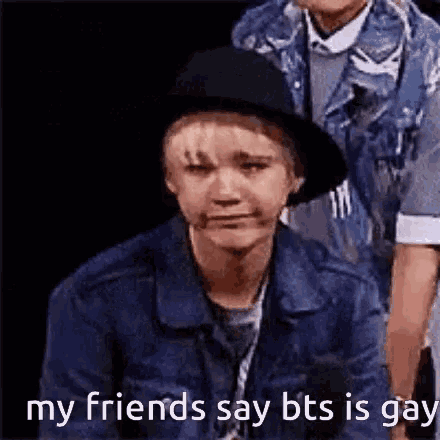 a boy in a hat is crying and says `` my friends say bts is gay ''