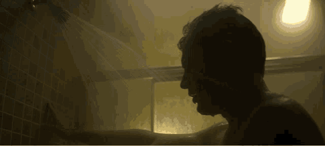 a man is taking a shower in the dark