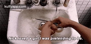 a person is washing their hands in a bathroom sink and saying `` nick loved a girl i was pretending to be '' .