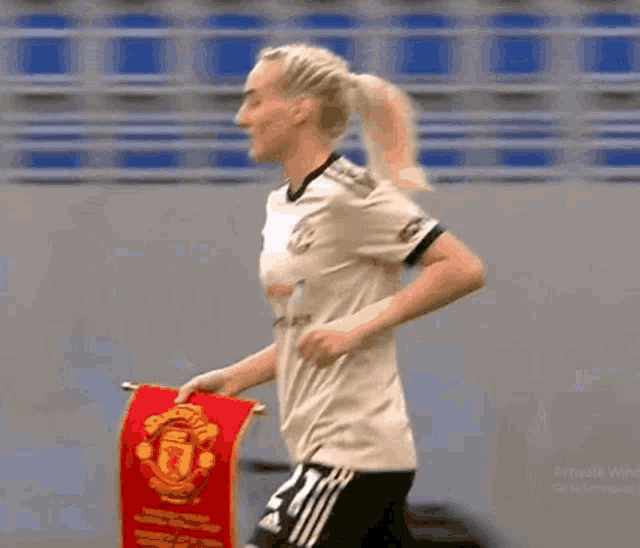 a female soccer player holds a banner that says united