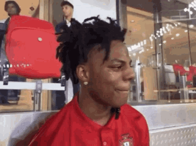 a young man with dreadlocks is wearing a red shirt with the number 13 on it