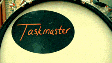 a drum with a black circle that says taskmaster