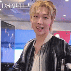 a man wearing a black leather jacket and a white shirt is smiling