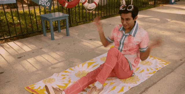 a man sitting on a towel with a sign that says polo