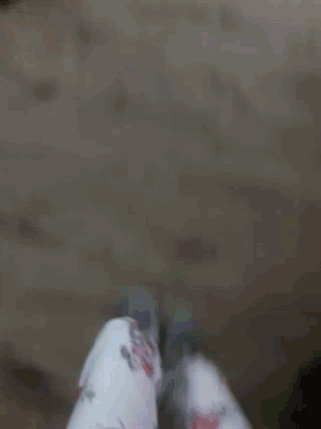 a blurred image of a person 's feet walking on a wooden floor