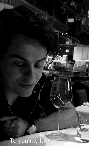 a man sits at a table with a glass of wine and the words " to you my love "