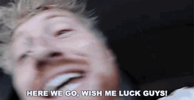 a close up of a man 's face with the words `` here we go , wish me luck guys '' written on it .