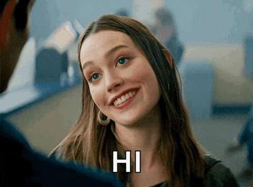 a woman is smiling and says hi to someone