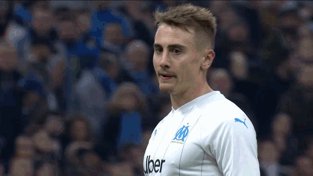 a soccer player wearing a white jersey with the word uber on the front