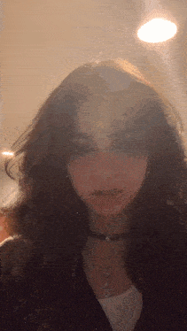 a close up of a woman 's face wearing a choker necklace and earrings