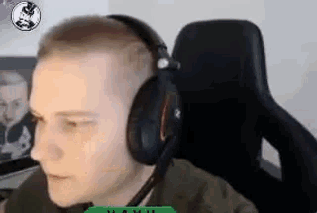 a man wearing headphones and a microphone is sitting in a gaming chair .