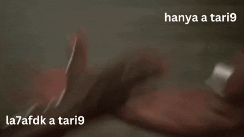 a man in a red shirt is arm wrestling with another man in a white shirt