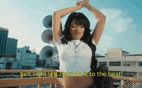 a woman is standing on a balcony with the words left right left right do it to the beat
