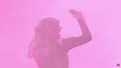 taylor swift is dancing on stage in front of a pink background while wearing a black dress .