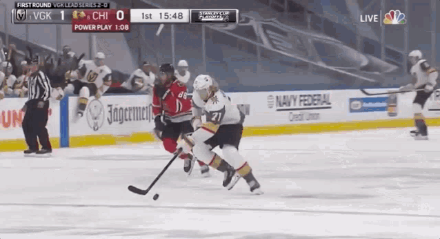 a hockey game is being played in front of an advertisement for jagermeister