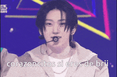 a man singing into a microphone with the words corazoncitos si eres de brii
