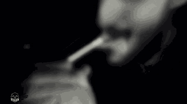a man with a beard is smoking a cigarette in a black and white photo
