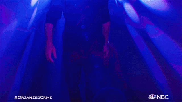 a man in a black shirt is standing in front of a purple background that says organized crime on the bottom