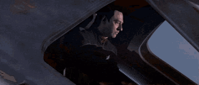 a man sitting in a cockpit with the words " what an asshole " written on the screen