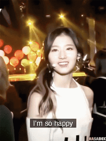 a woman says i 'm so happy in front of a crowd of people