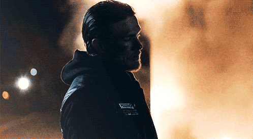 a man wearing a jacket with the word sons of anarchy written on it