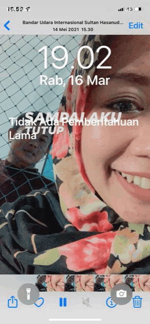 a phone screen shows a picture of a woman and the time is 19:02