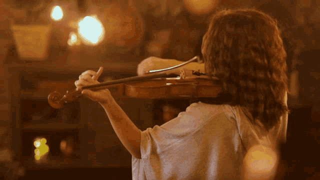 a woman is playing a violin with a hood on
